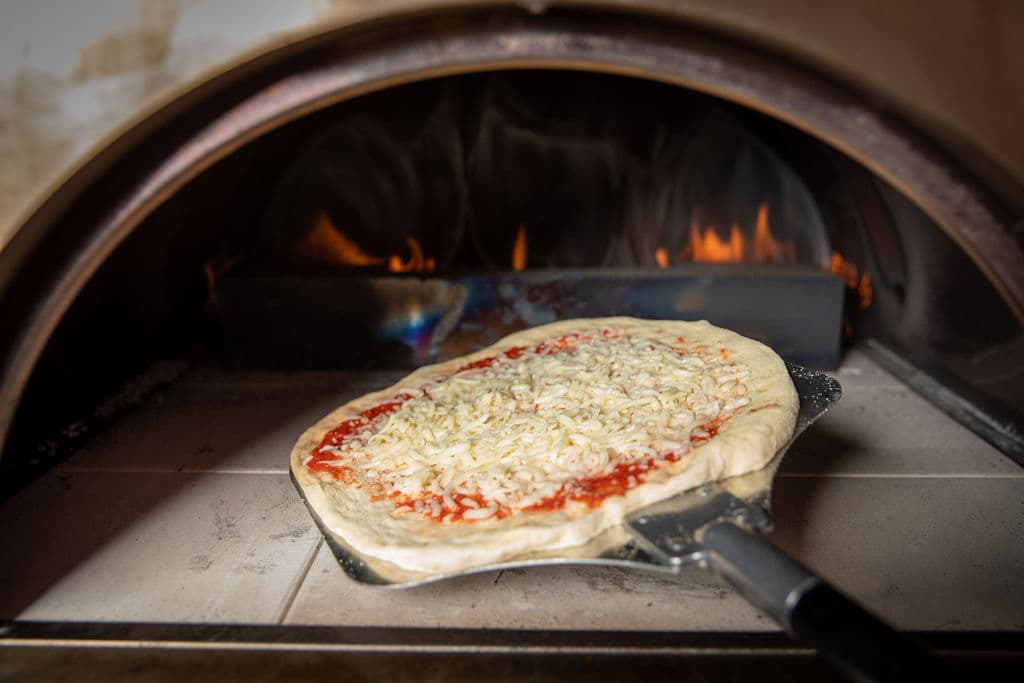 Wood-fired pizza served live at a Miami event